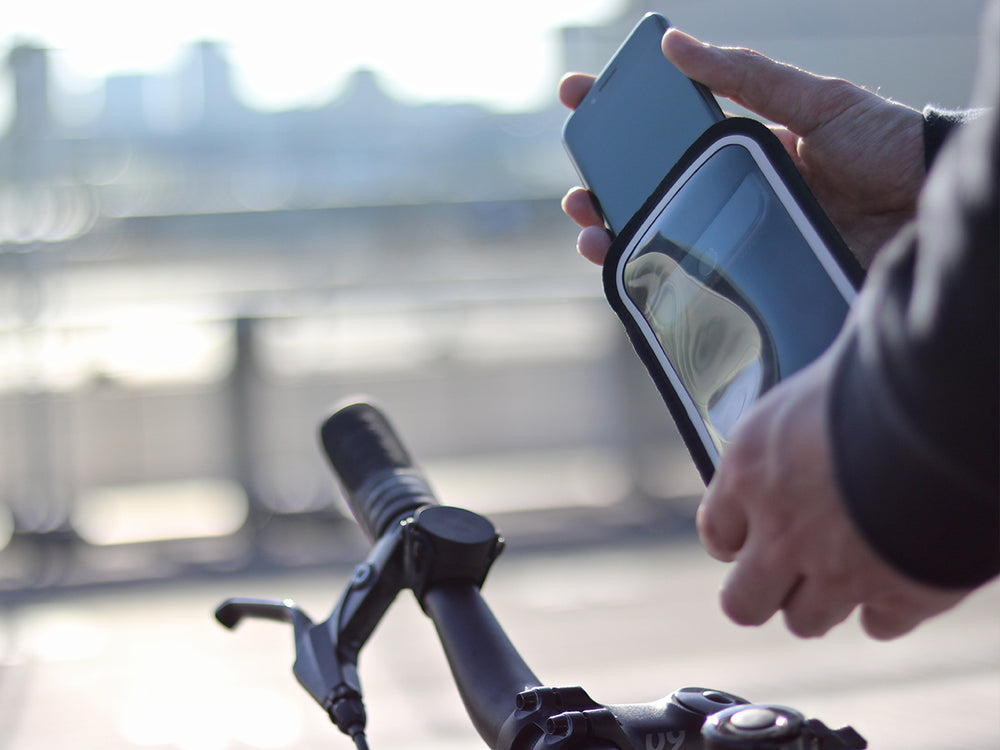 Insertion du smartphone dans la pochette Shapeheart magnétique, protection contre la pluie et les vibrations