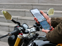 Insertion du téléphone dans la pochette magnétique Shapeheart, pratique pour des trajets sécurisés en moto.